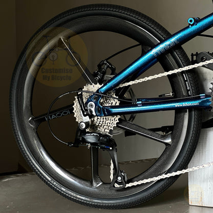 Close-up of a folding bike rear wheel and frame, showing a black carbon fiber wheel, silver cassette, and a metallic blue frame with 'HAOOi' branding.