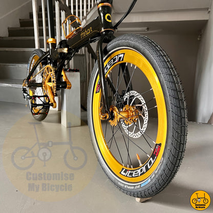 Black and yellow bicycle with 'Customise My Bicycle' branding on a staircase background