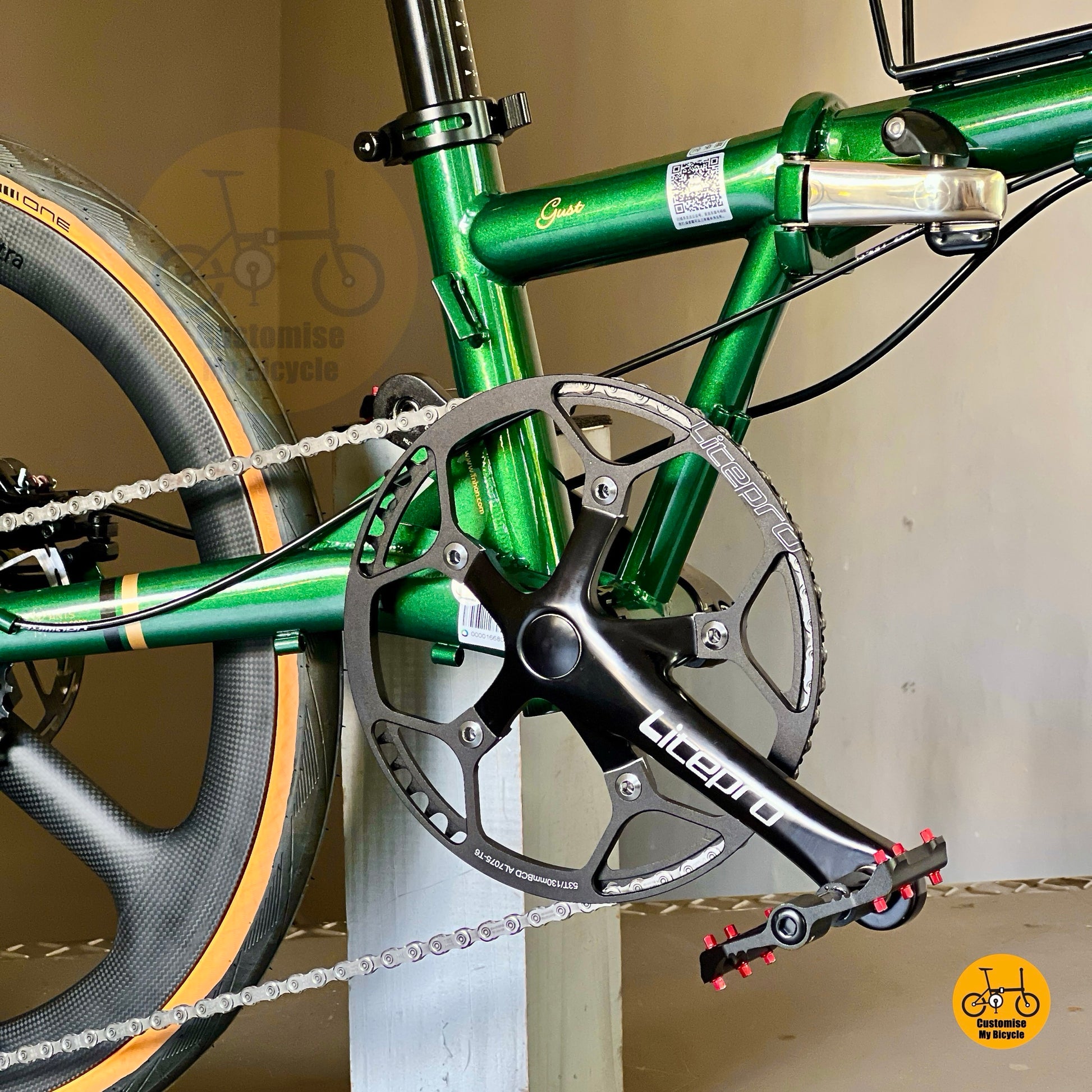 Close-up of a green bicycle with chain and gear system against a plain background
