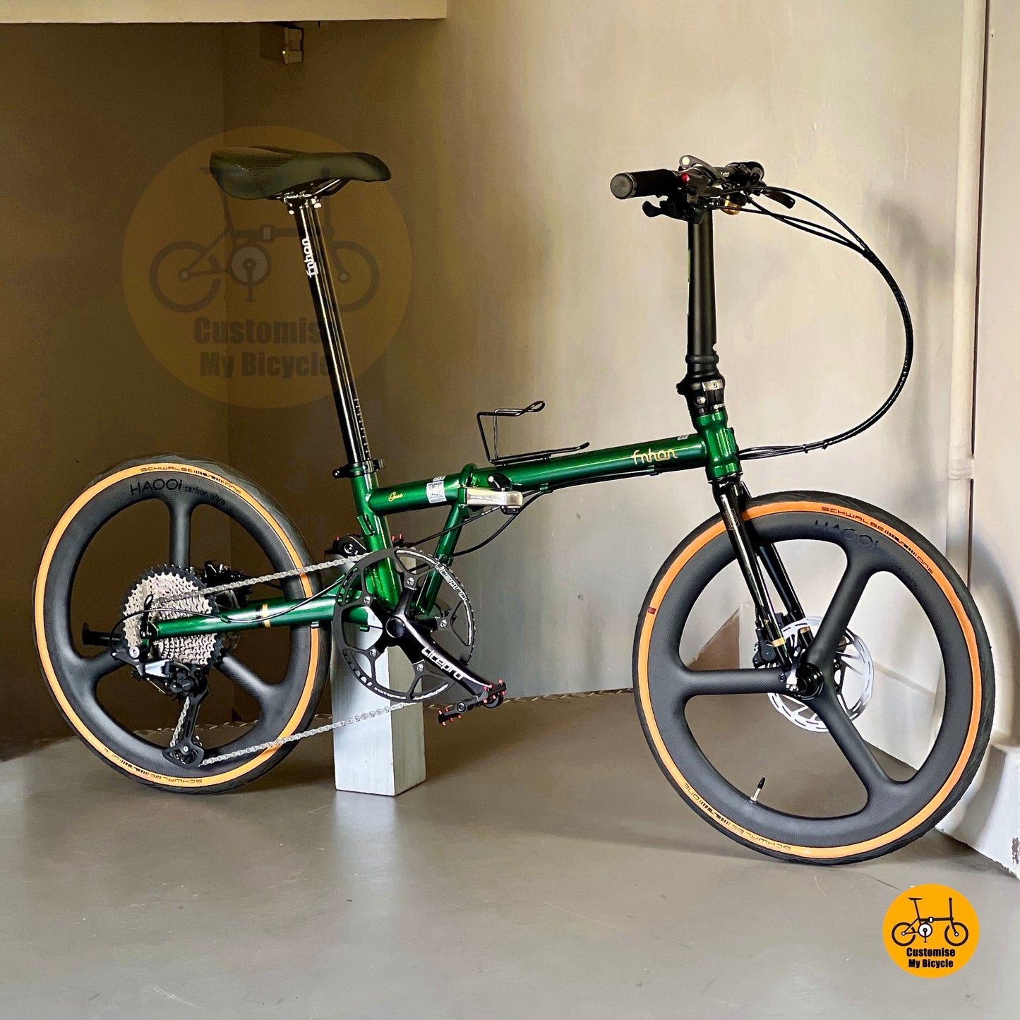 Green folding bicycle with black seat and tires on a white background