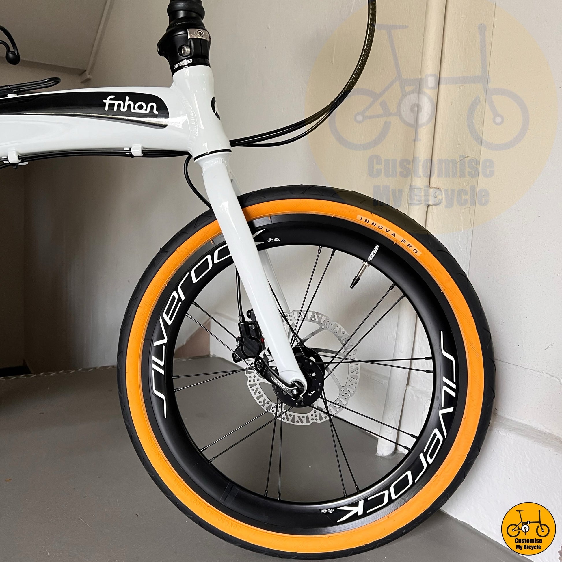 Folding bicycle with tan wall tyres and white frame  
