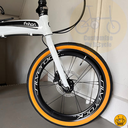 Folding bicycle with tan wall tyres and white frame  

