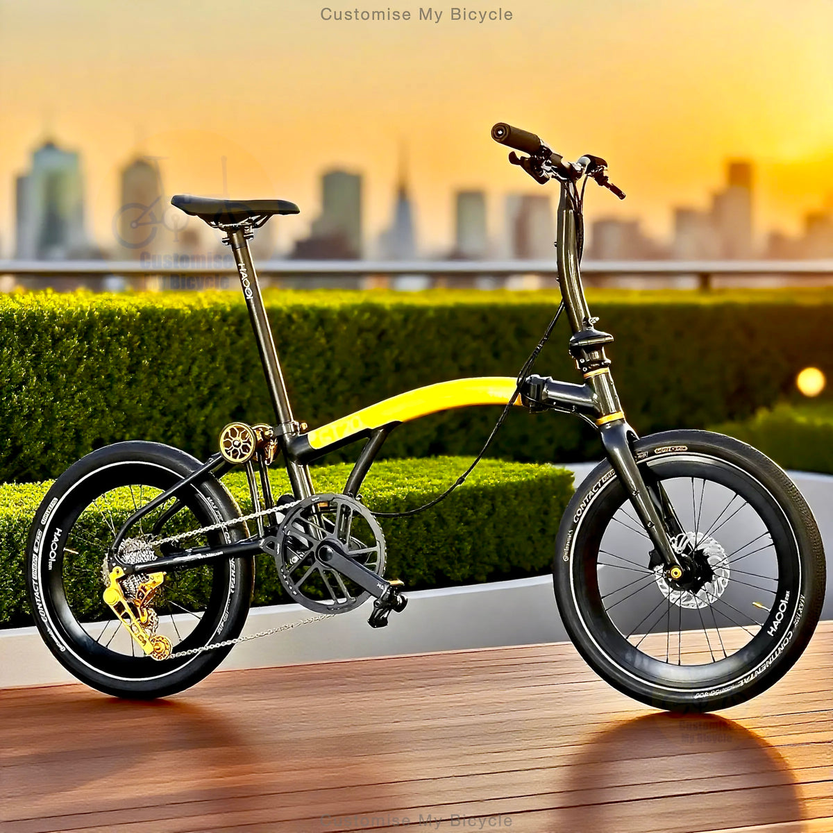 A folding bicycle with a black frame and bright yellow handlebar bar-end, photographed outdoors on a wooden deck with a blurred city skyline and hedges in the background at sunset.